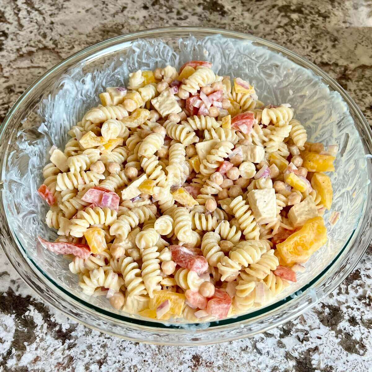 Creamy pasta salad in a glass mixing bowl.
