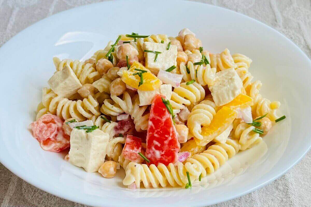 Pasta salad in a white bowl.