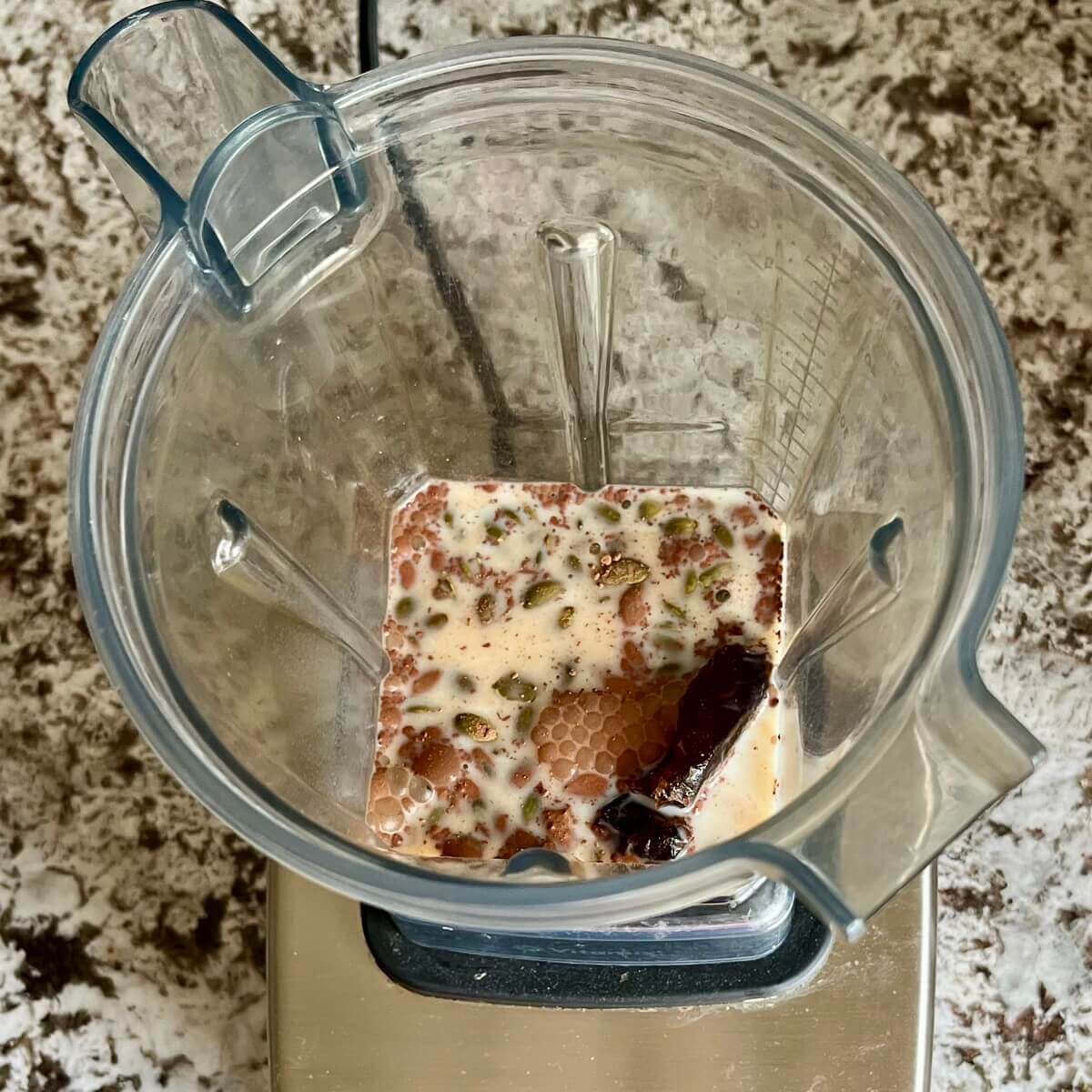 Pumpkin seeds, dates, cocoa powder, sea salt, and soy milk in a blender.