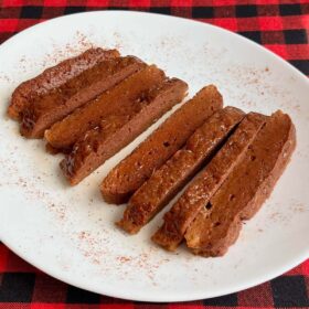 Sliced baked seitan on a white serving dish.