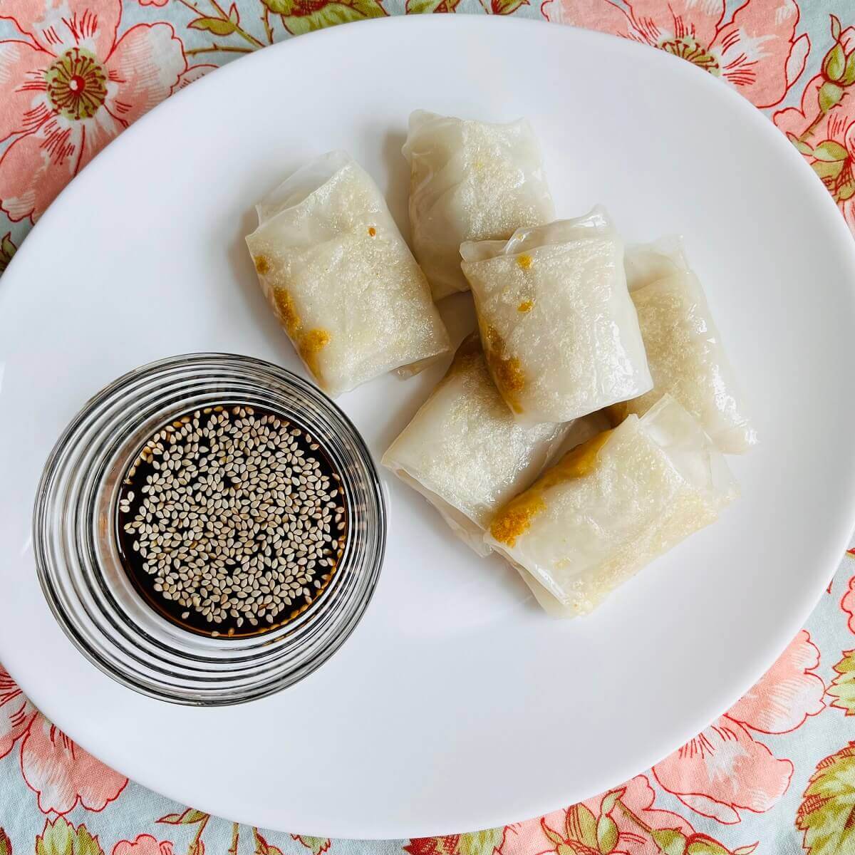 Chickpea dumplings and a bowl of dipping sauce on a white plate.