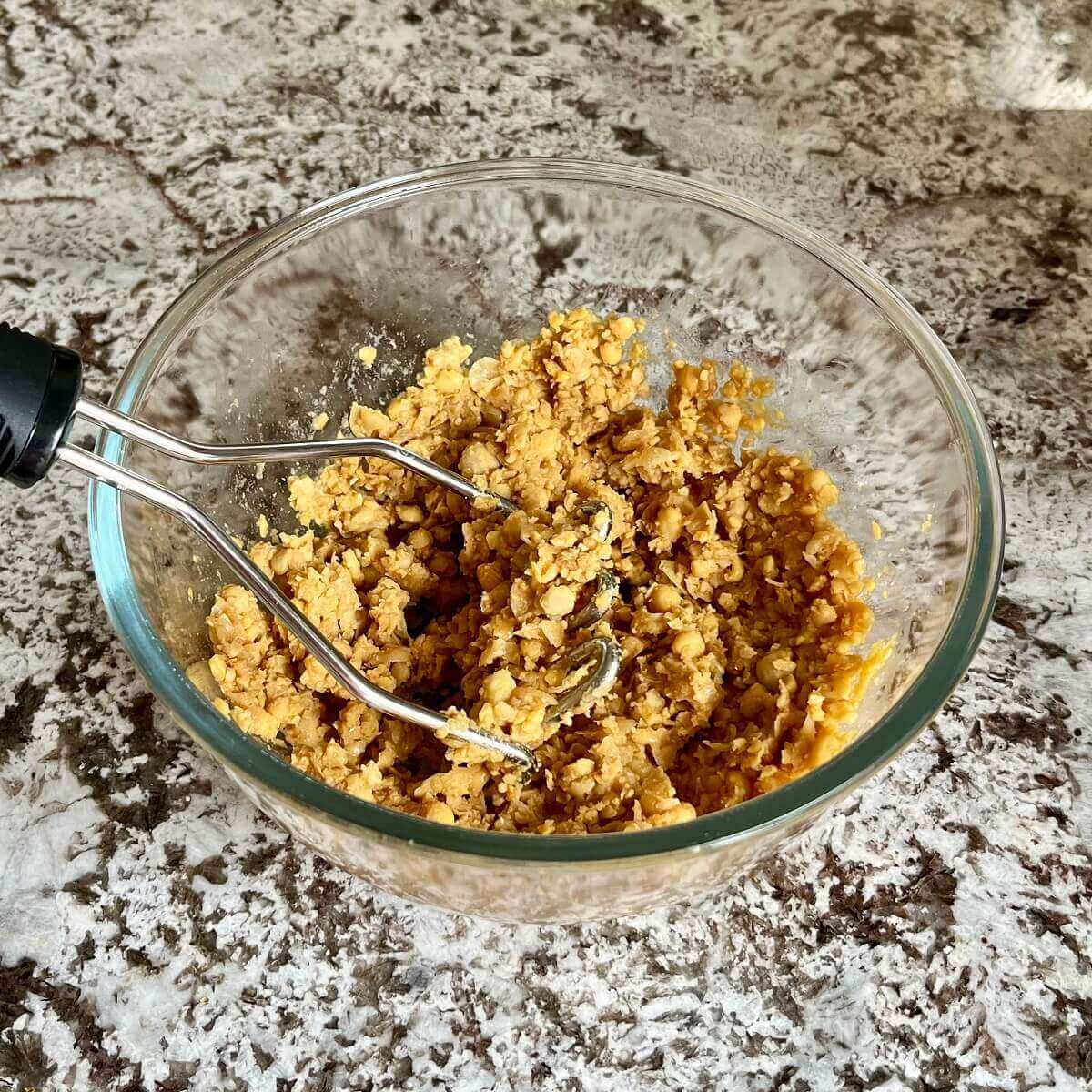Mashed chickpea filling for dumplings in a glass mixing bowl.