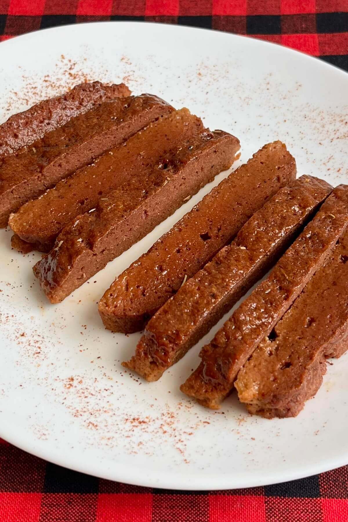 Roasted seitan on a plate sprinkled with cayenne pepper.