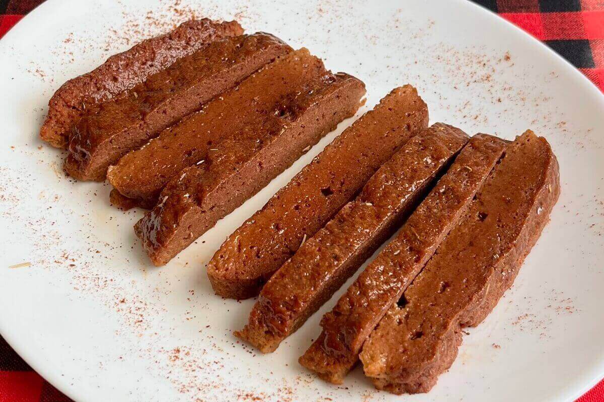 Slices of seitan on a white plate.