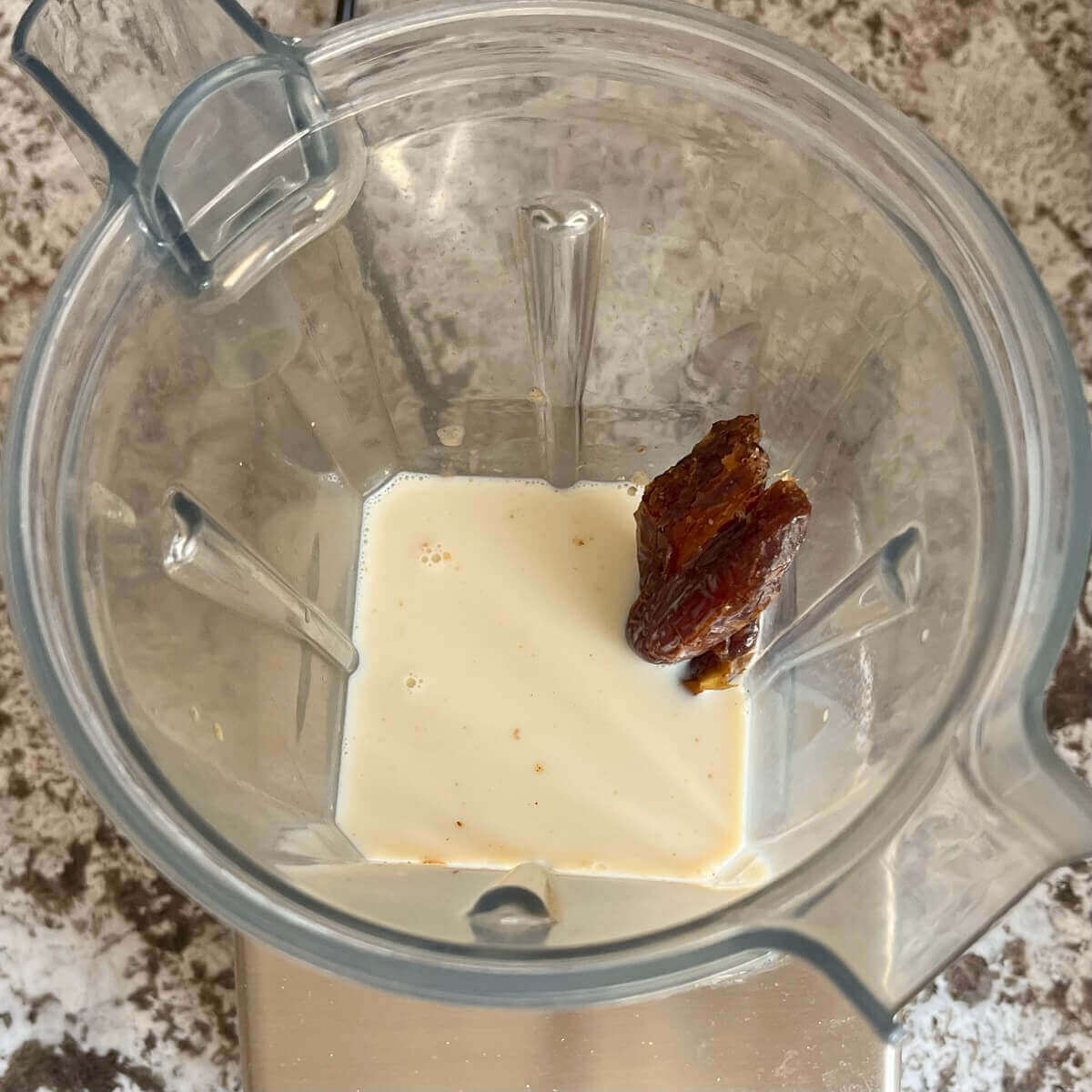 Sea salt, dates, vanilla, almond butter, and soy milk in a blender.