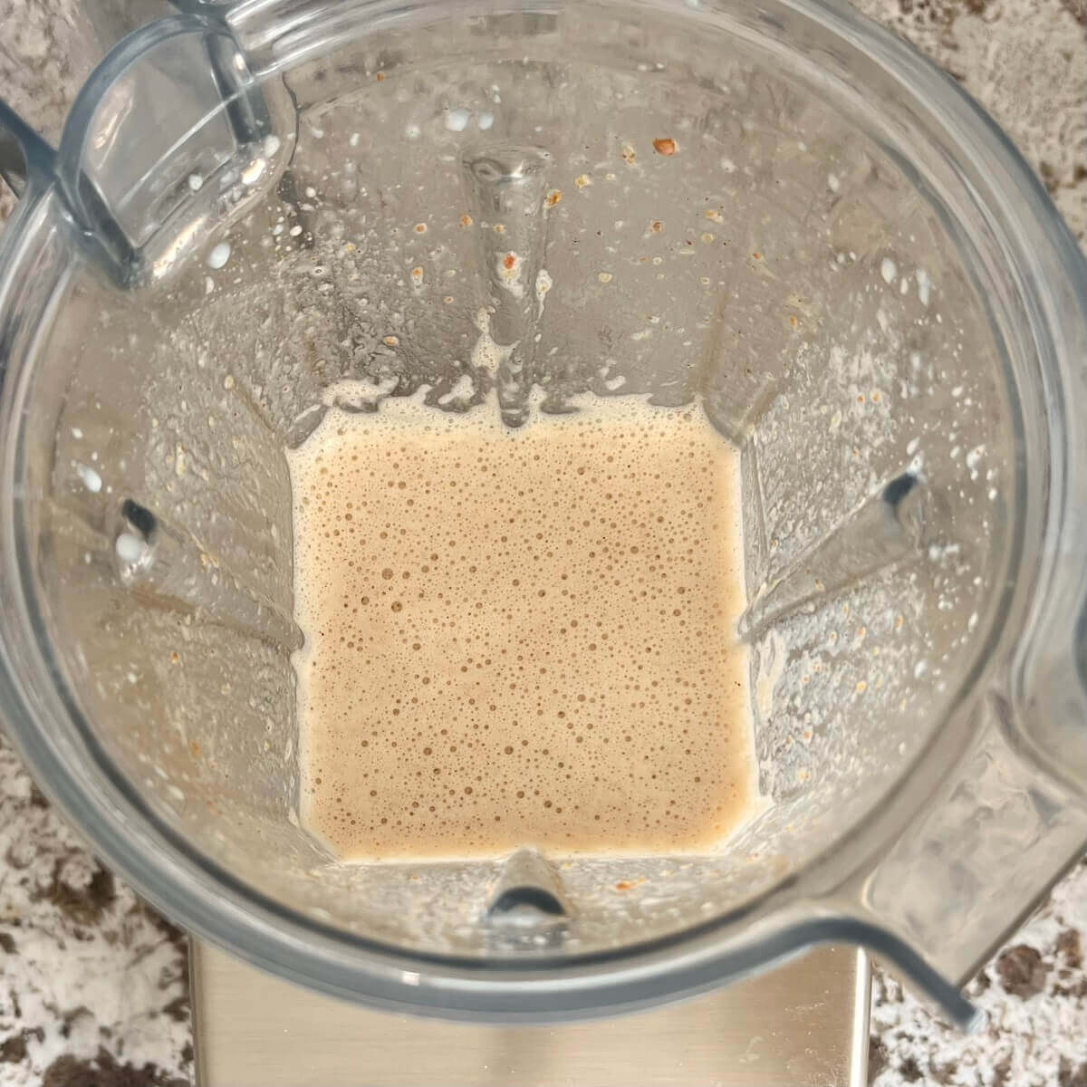 A creamy beige smoothie in a blender.