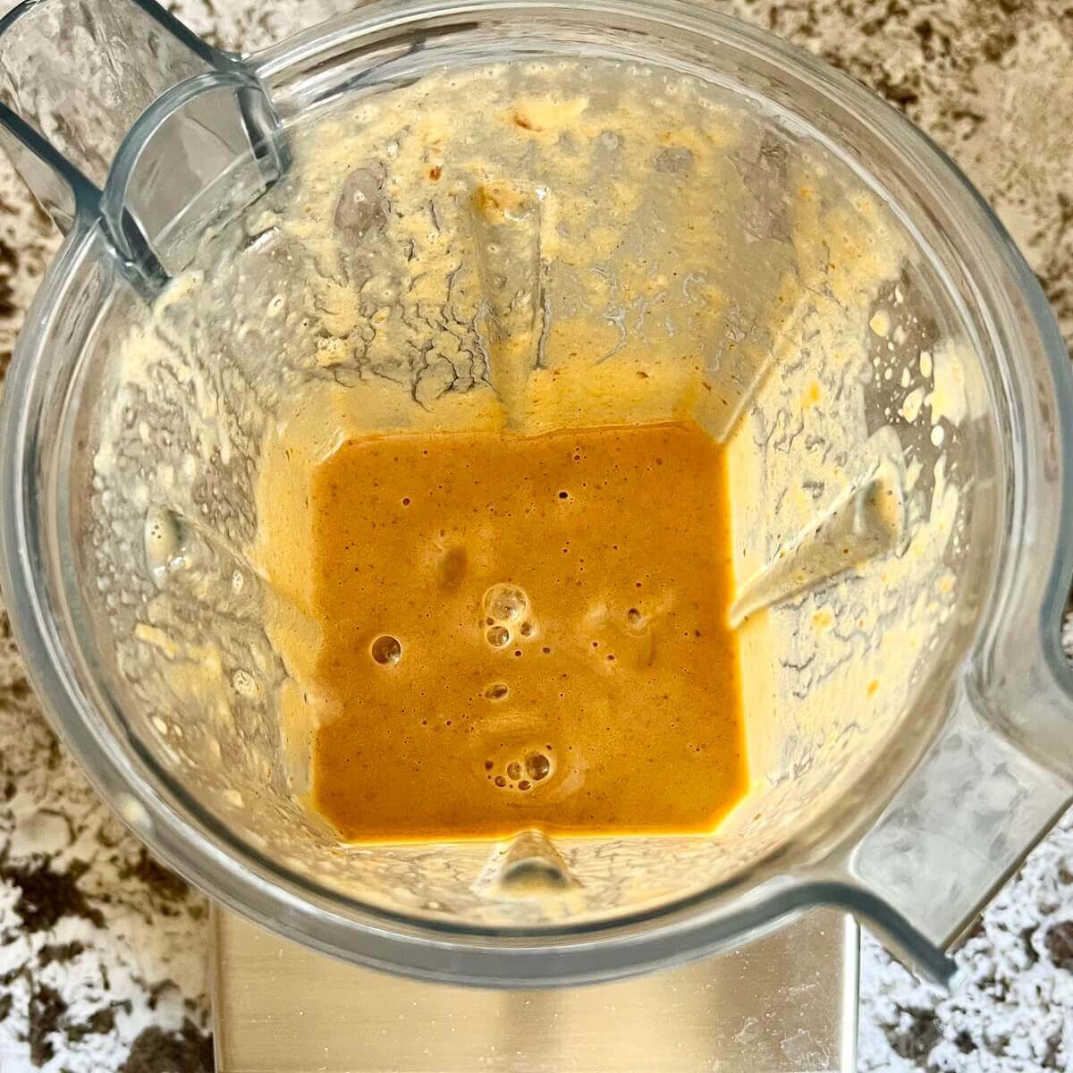 A creamy pumpkin spice smoothie in a blender.
