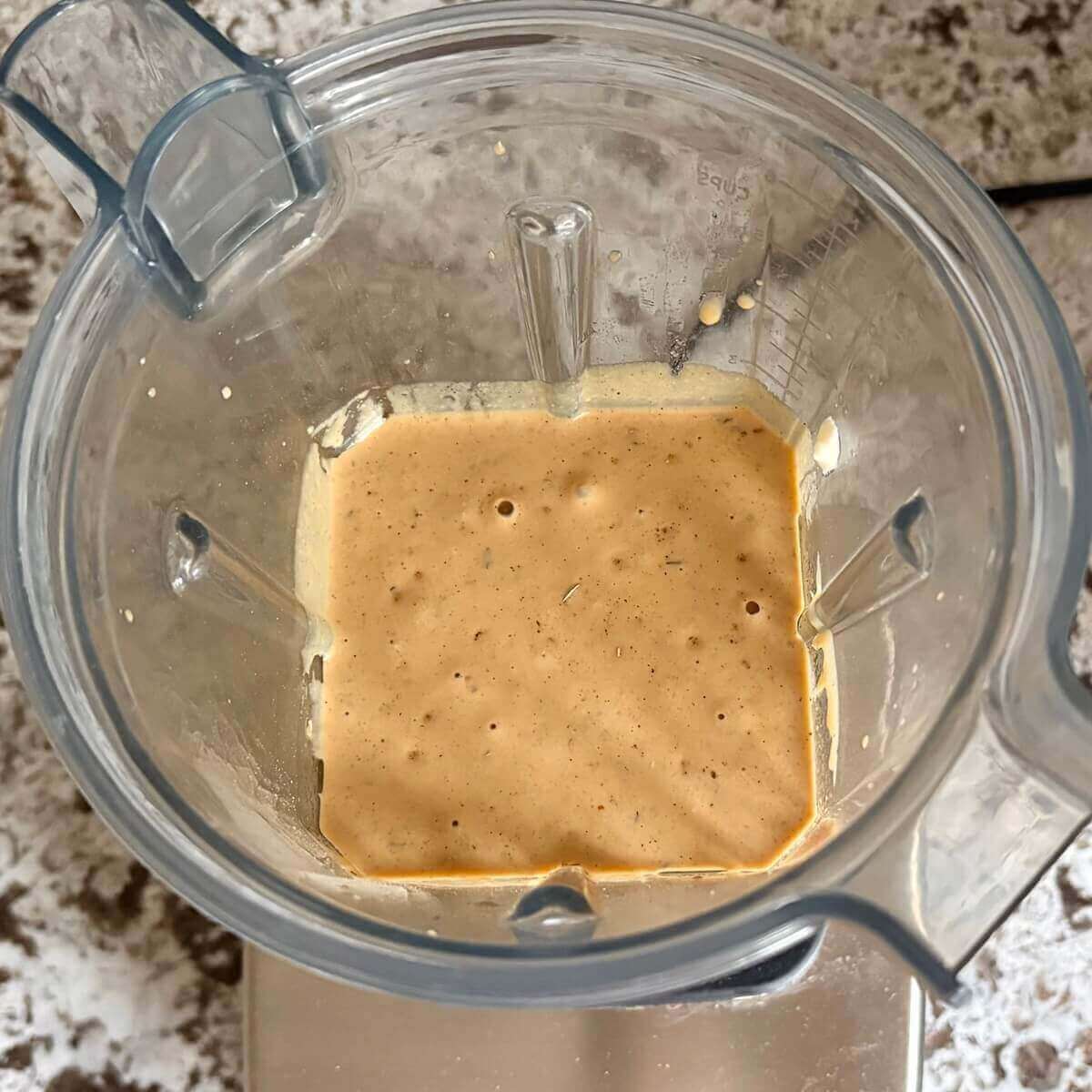 A creamy beige liquid in a blender.
