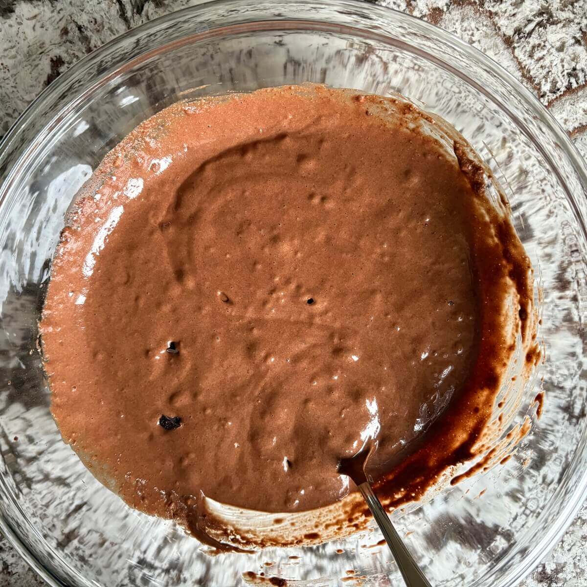 Cake batter made with oat flour in a glass mixing bowl.