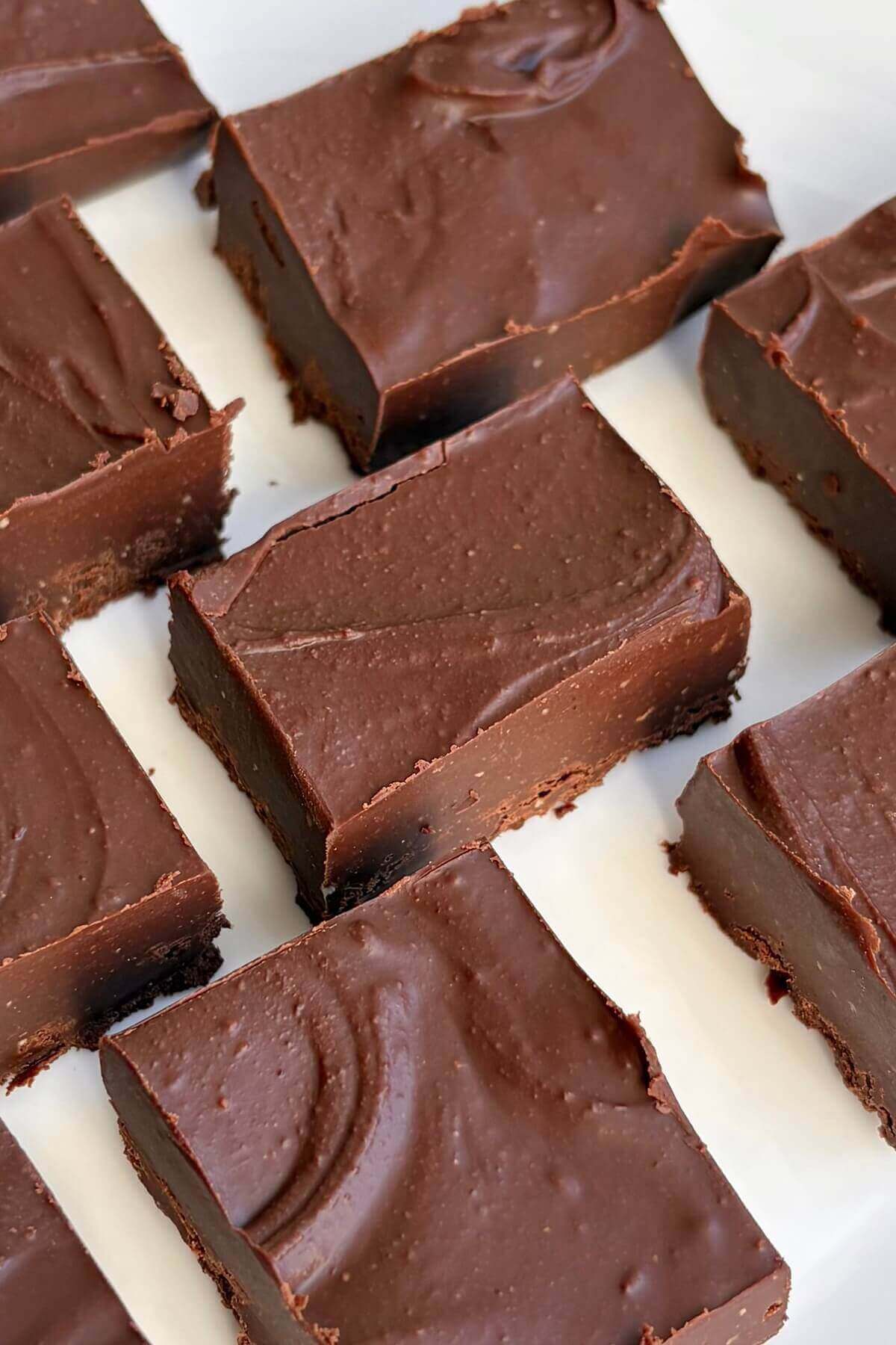 Portions of almond butter chocolate fudge on a white plate.