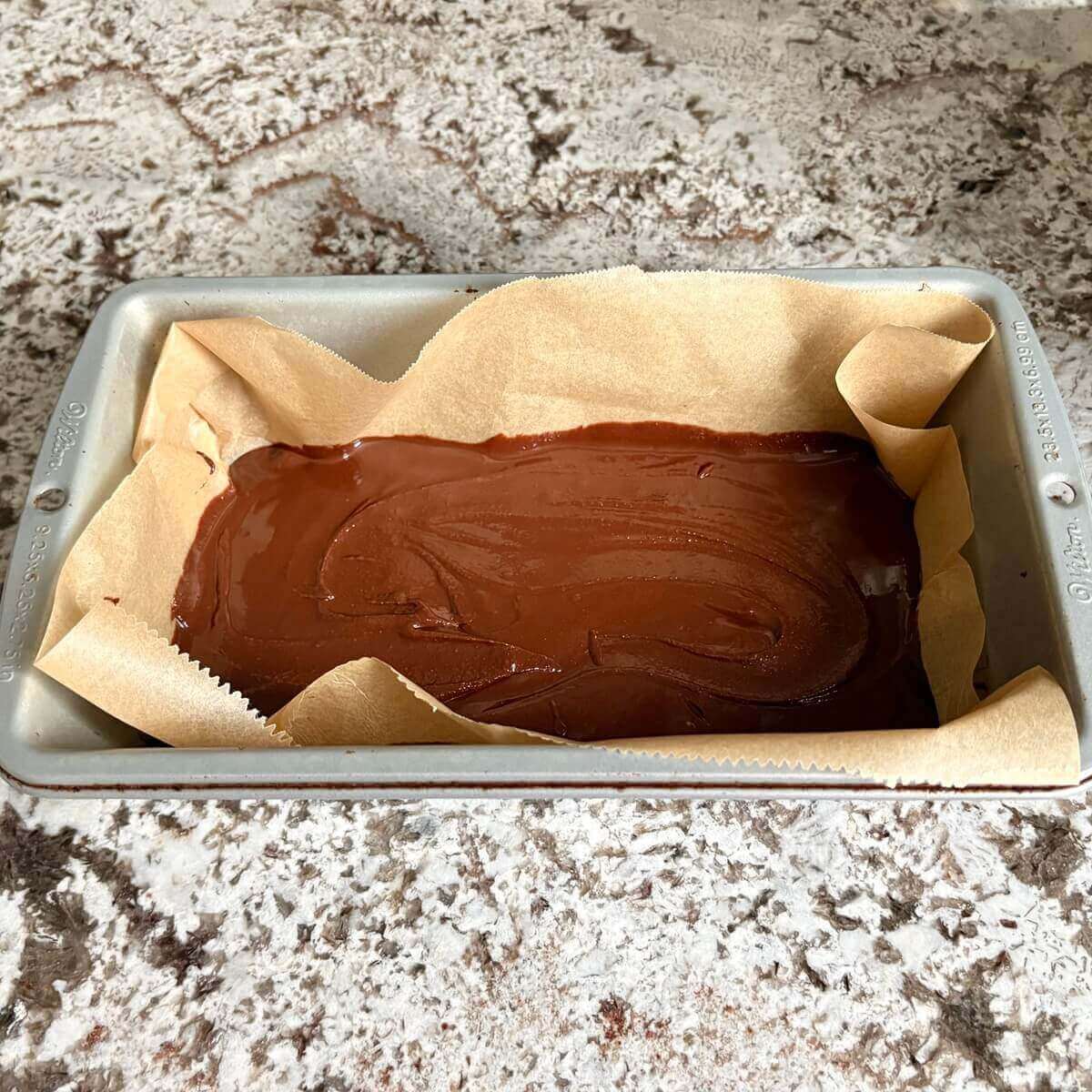 Unset fudge in a loaf pan lined with parchment paper.