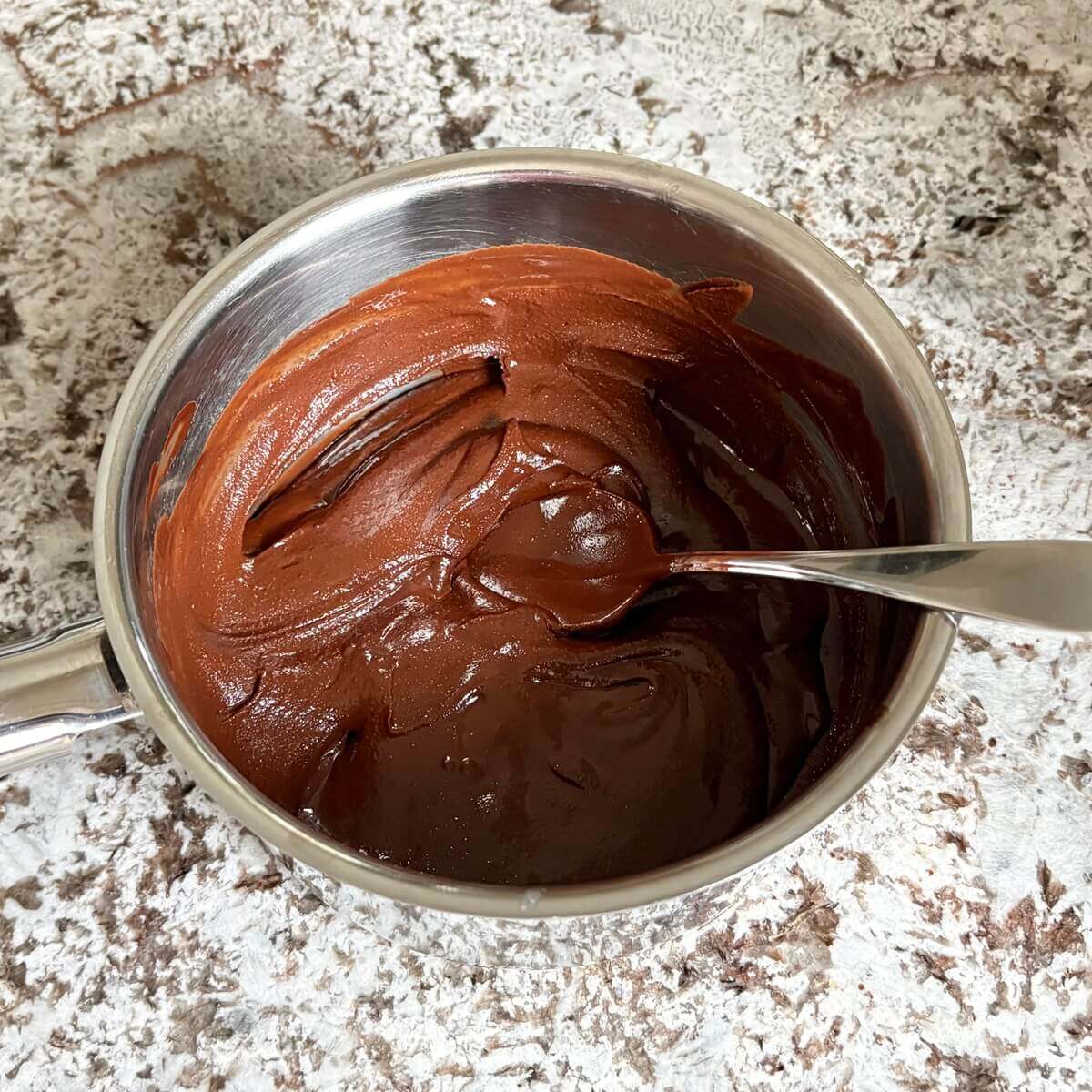 Mixing fudge batter in a steel pan.