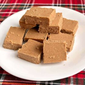 Keto gingerbread fudge squares piled on a white plate.