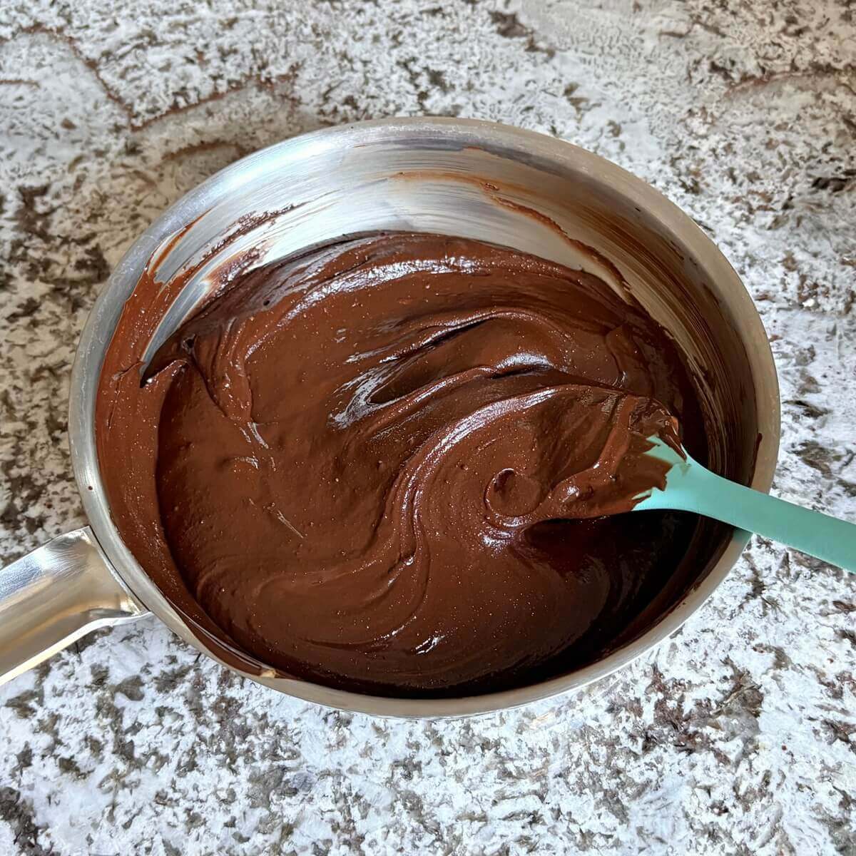 Melted chocolate and almond butter in a steel pan.