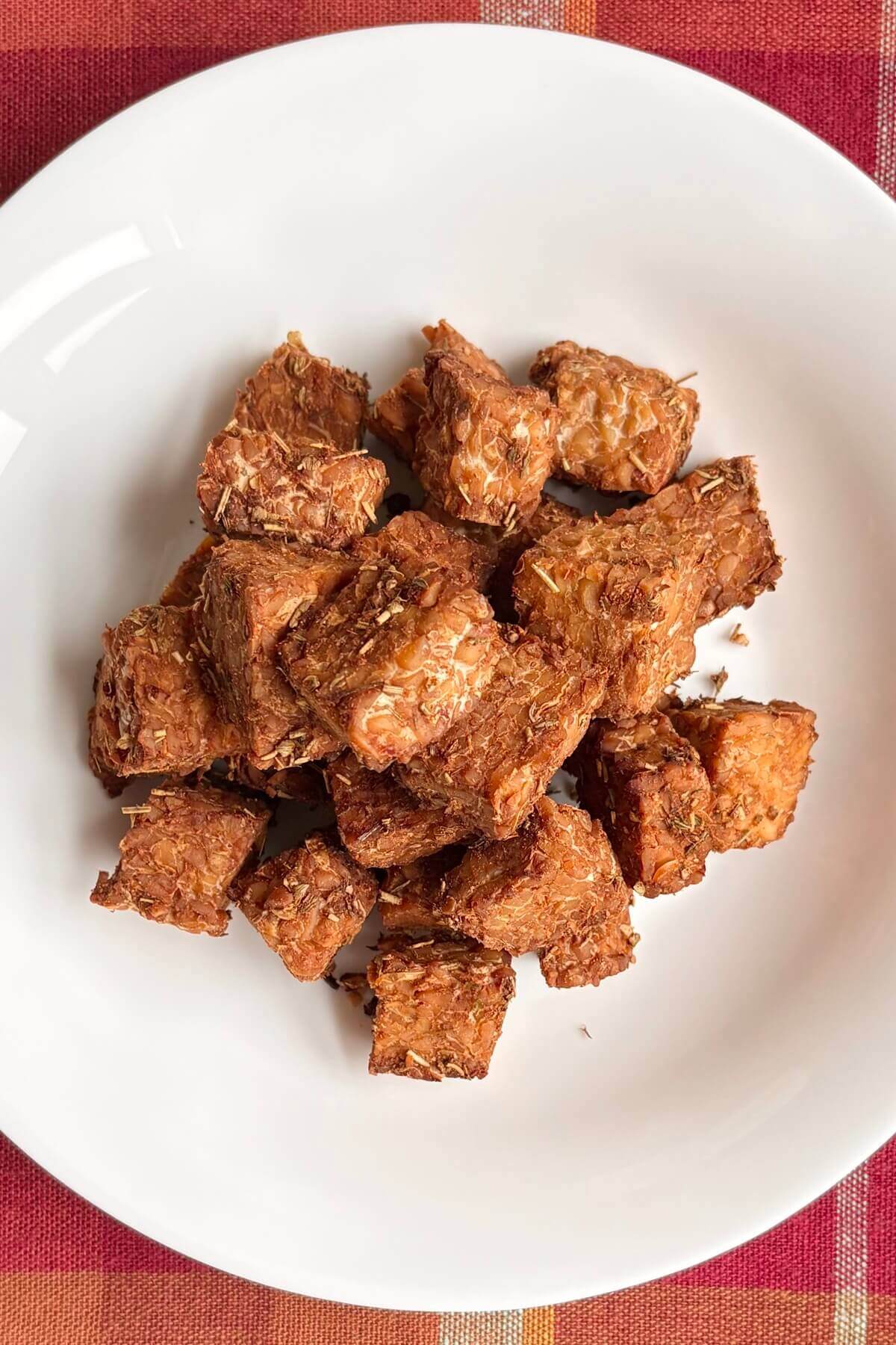 Roasted marinated tempeh in a white bowl.