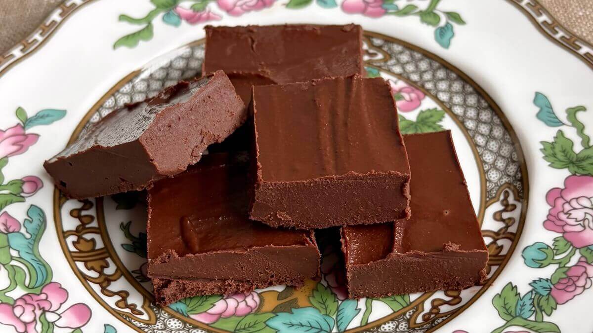 Squares of tahini fudge piled on a vintage plate.