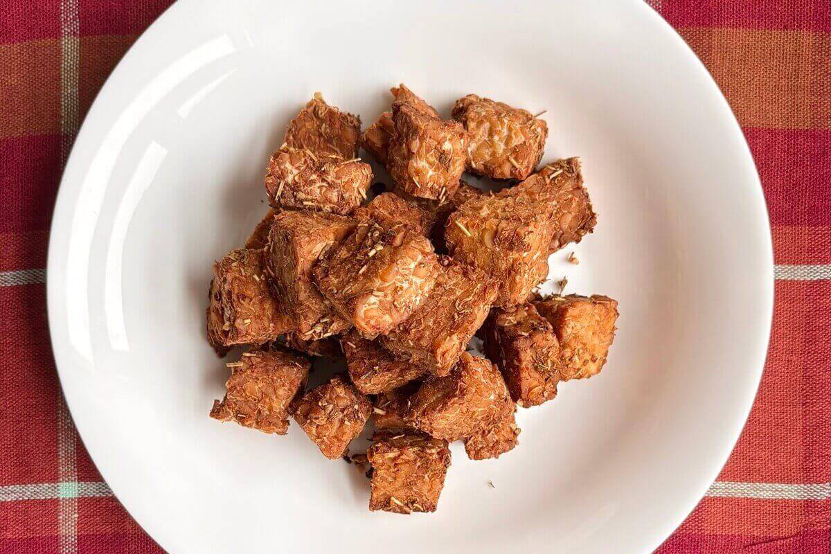 Bite-sized pieces of cooked tempeh in a bowl.