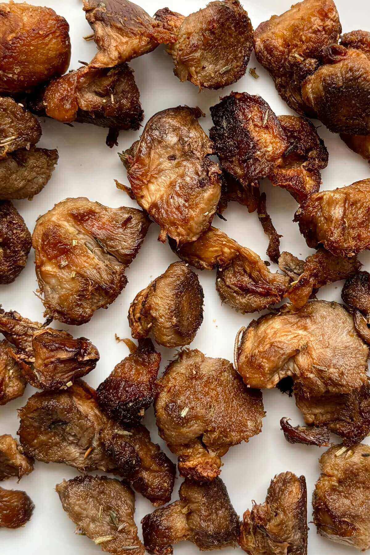 Baked pieces of lion's mane mushrooms on a white plate.