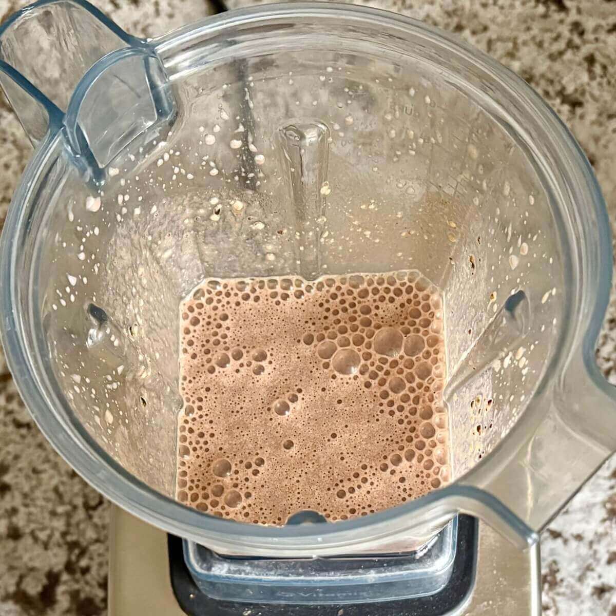 Hemp hearts and other smoothie ingredients blended in a blender.
