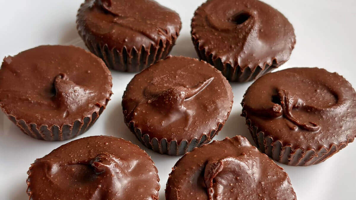 Seven hazelnut butter cups on a white plate.