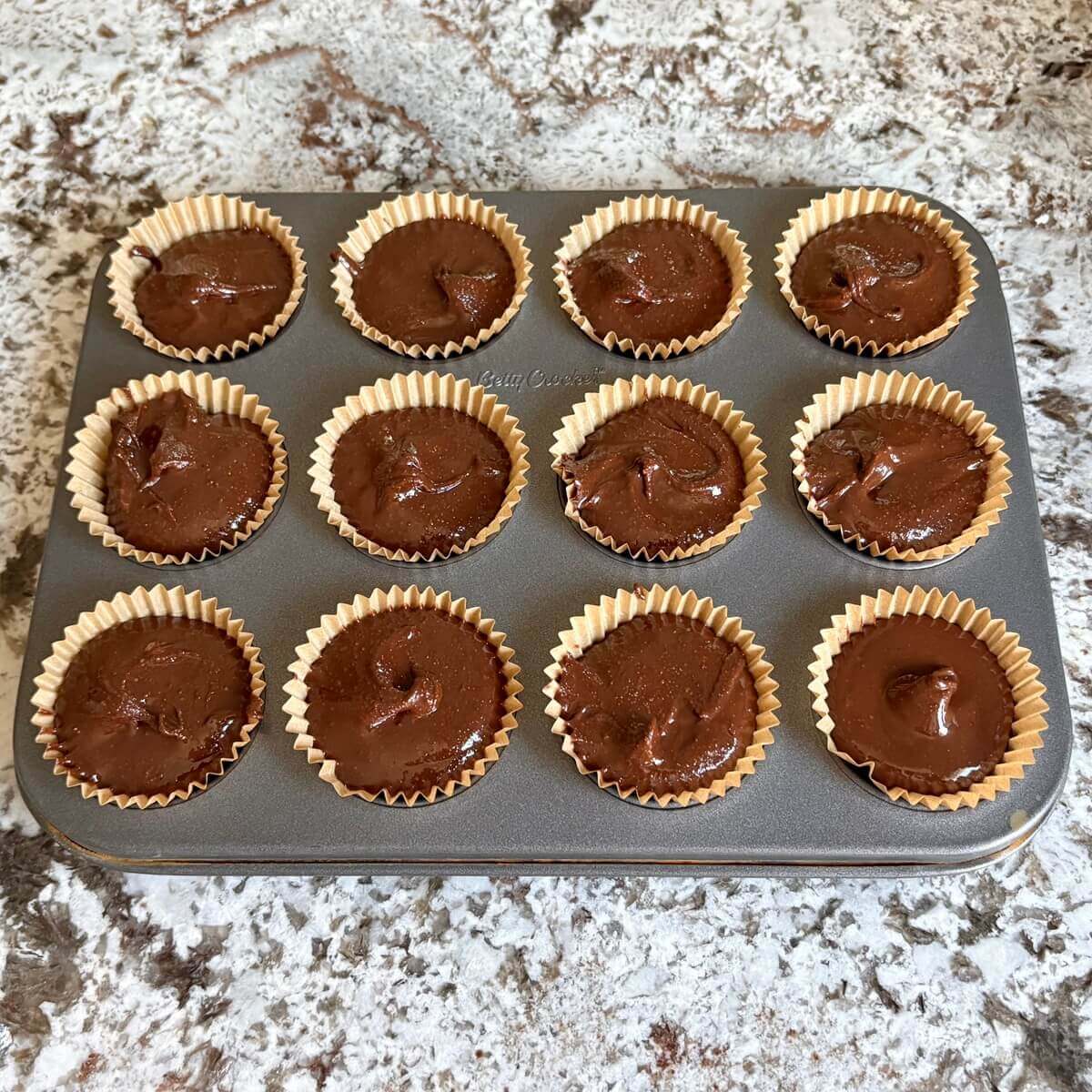 Hazelnut chocolate cups in a mini muffin pan.