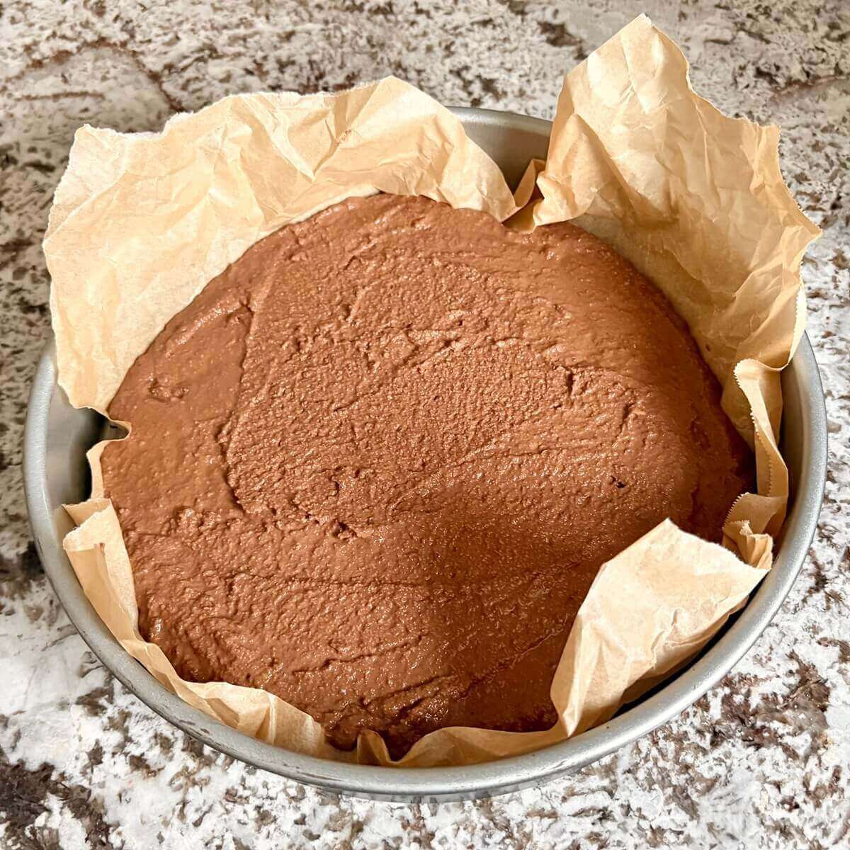 Low-carb cake batter in a pan lined with parchment paper.