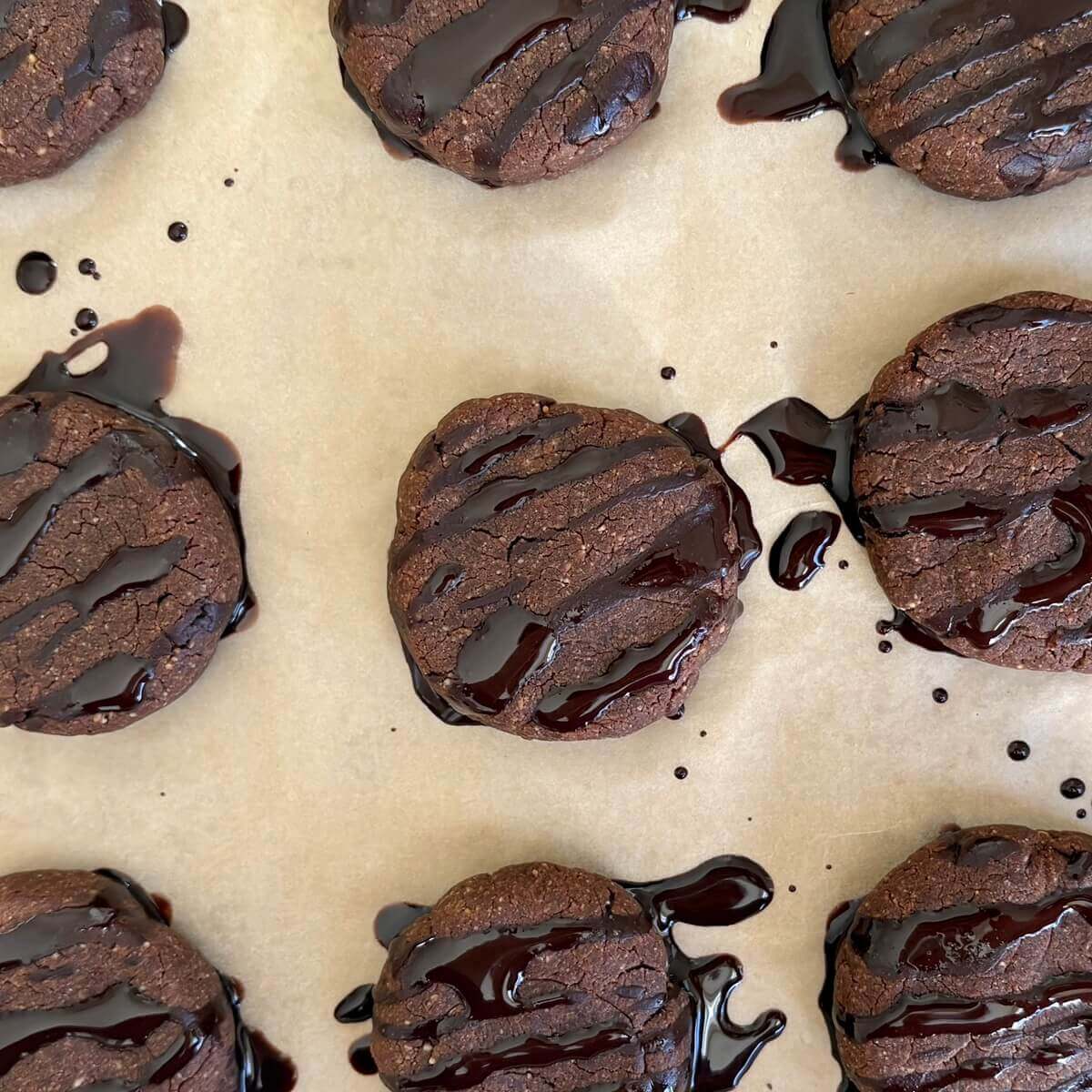 Low-carb chocolate peanut butter cookies on a sheet pan lined with parchment paper.