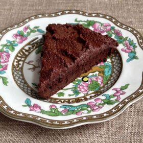 A slice of chocolate monk fruit cake on a vintage plate.
