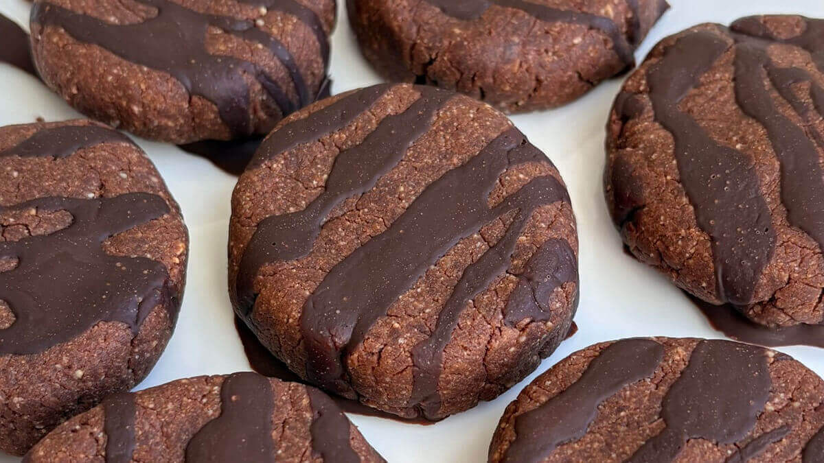 Monk fruit cookies drizzled with chocolate on a plate.