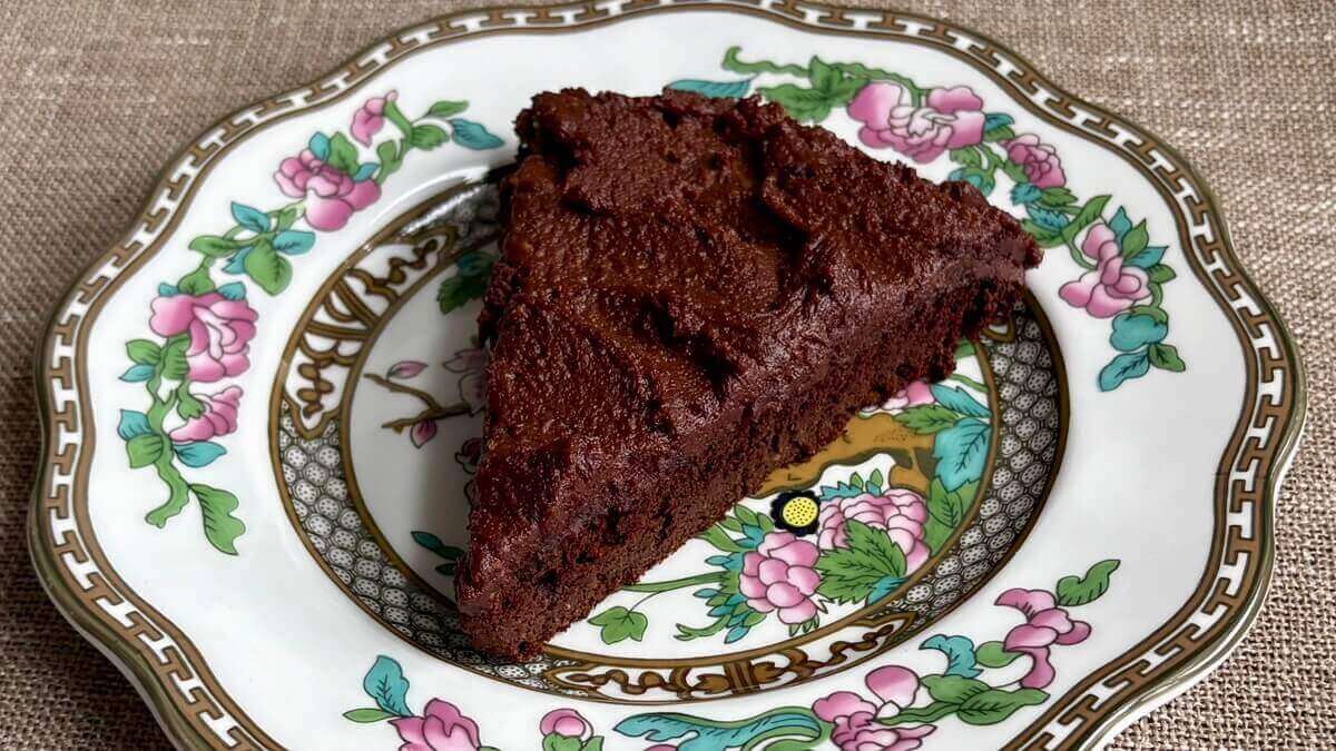 A slice of cake with monk fruit frosting on a vintage plate.