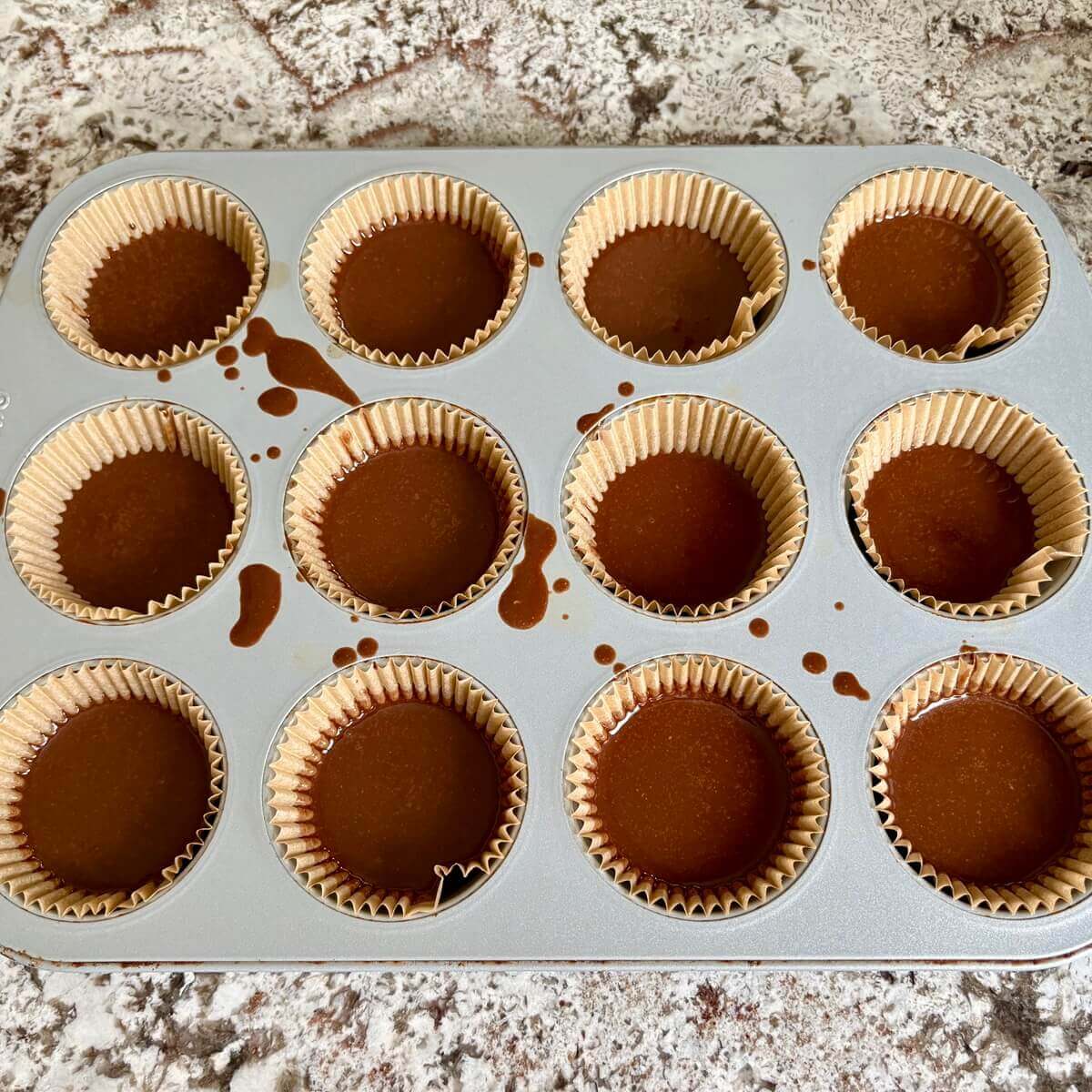 Keto chocolate treats in a muffin pan lined with paper baking cups.