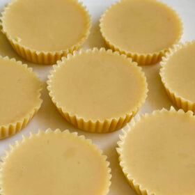 Seven lemon fat bombs on a white plate.