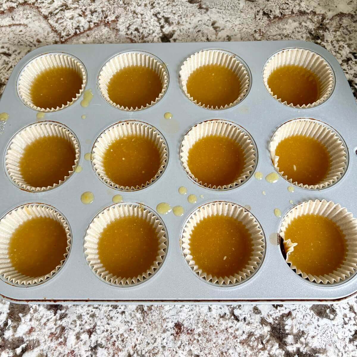 Lemon mixture evenly divided in a muffin pan lined with paper baking cups.