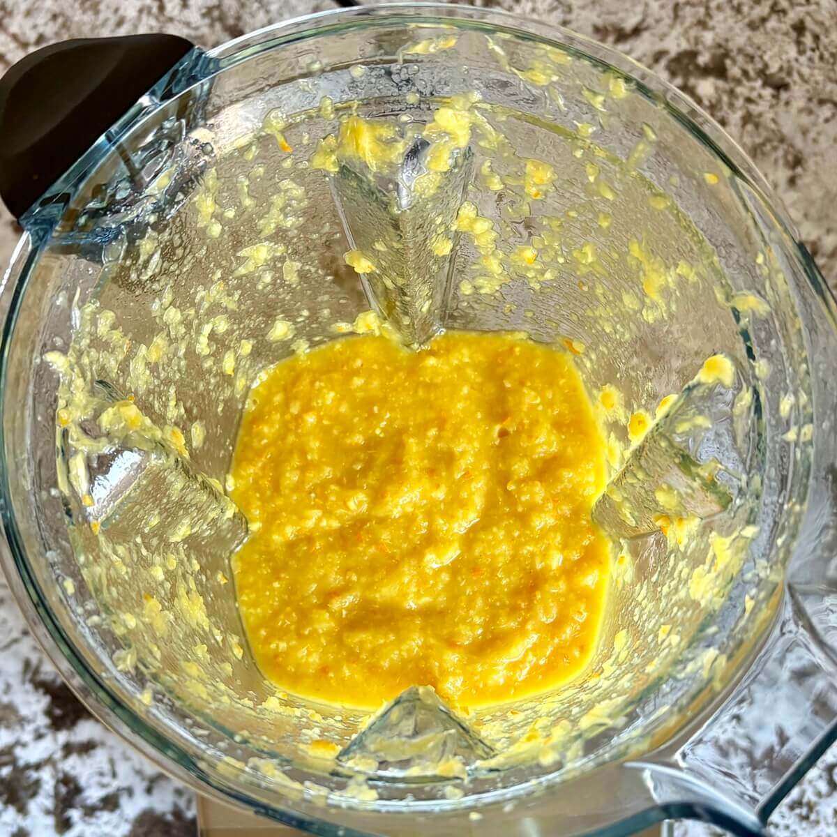 Oranges and other ingredients blended in a blender.