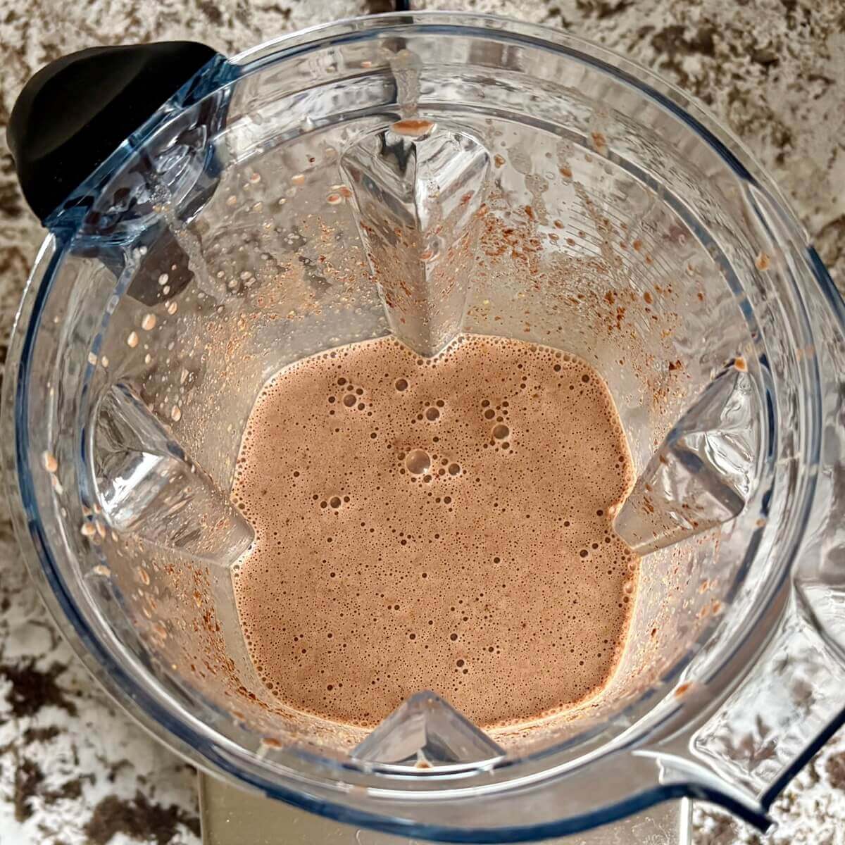 Flaxseed and other ingredients for pudding blended in a blender.