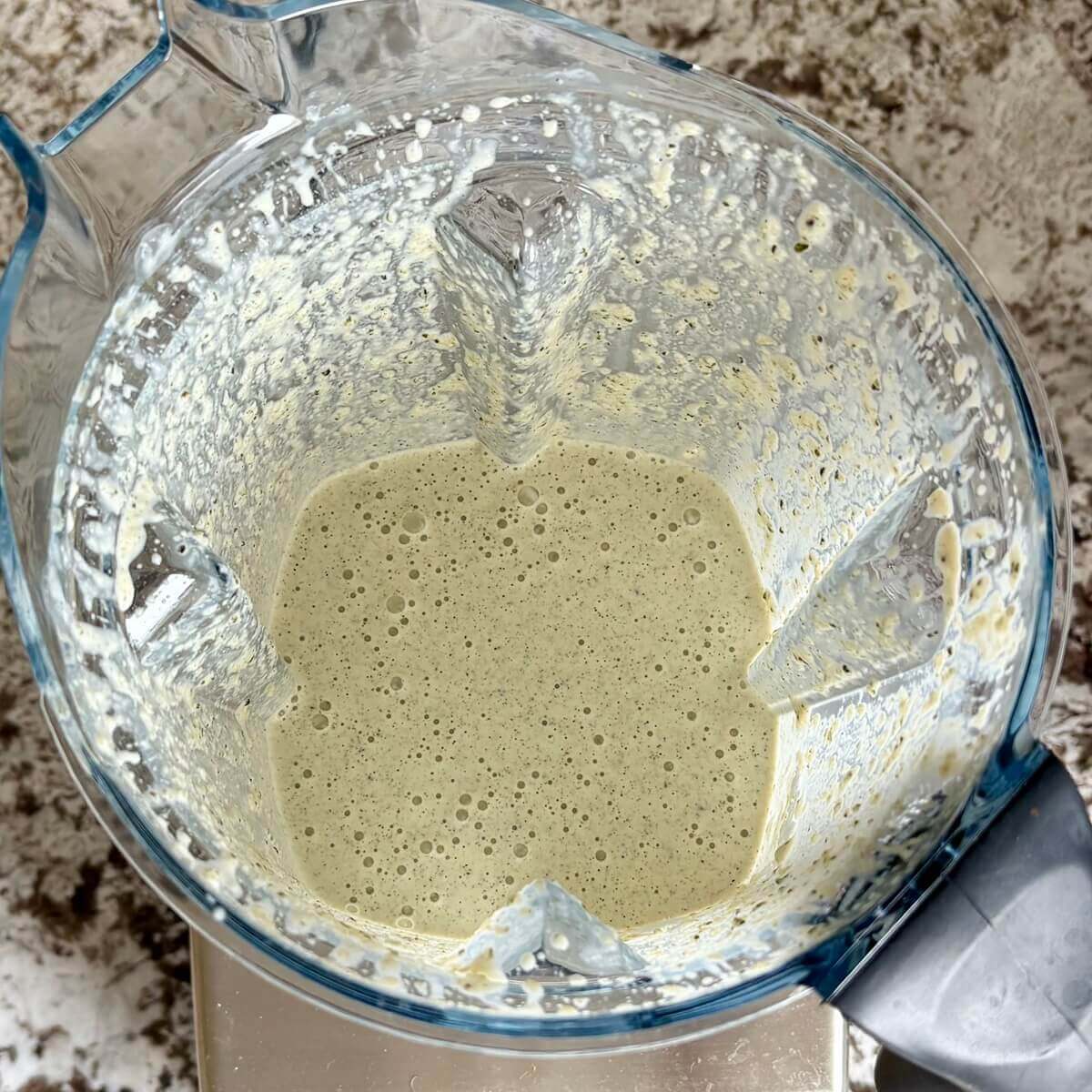 Hemp hearts and other ingredients for vegan cheese blended in a blender.