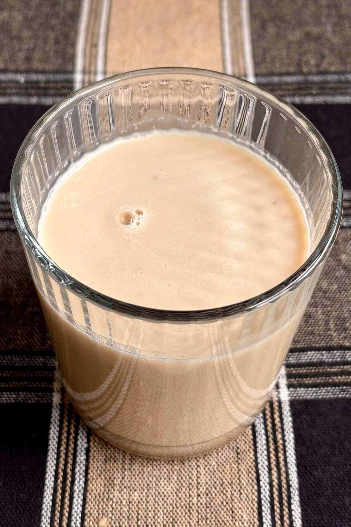 A peanut butter powder smoothie in a glass.
