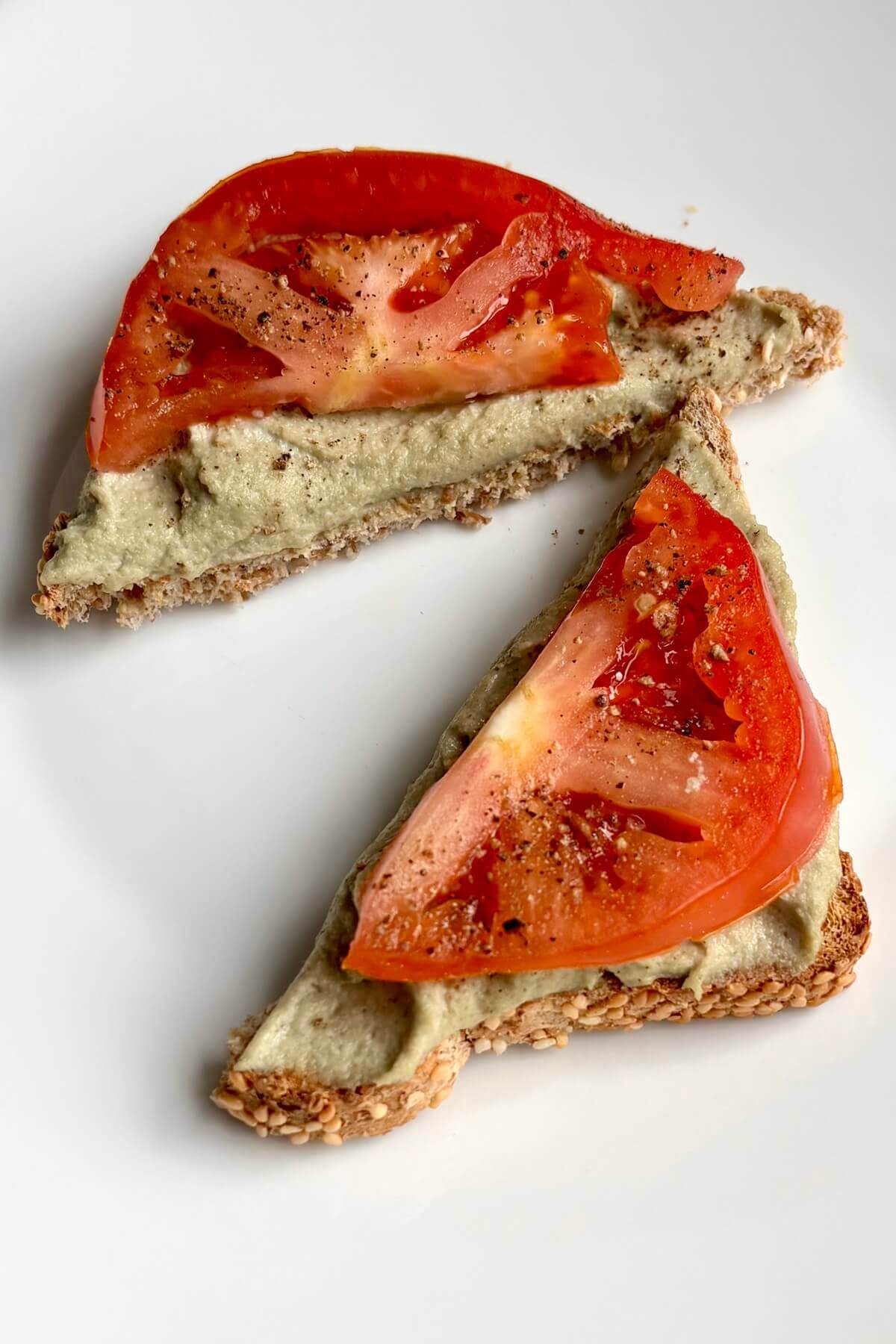 Toast with vegan cheese and tomato on a plate.