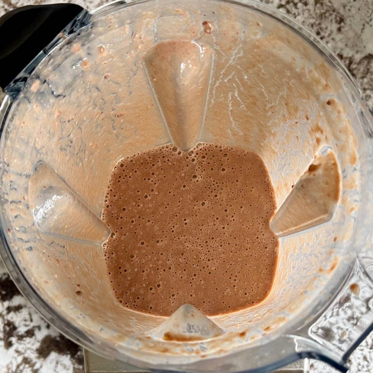 A creamy smoothie made with lentils blended in a blender.