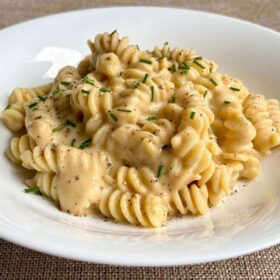 Pasta smothered in a chickpea cream sauce in a white bowl.
