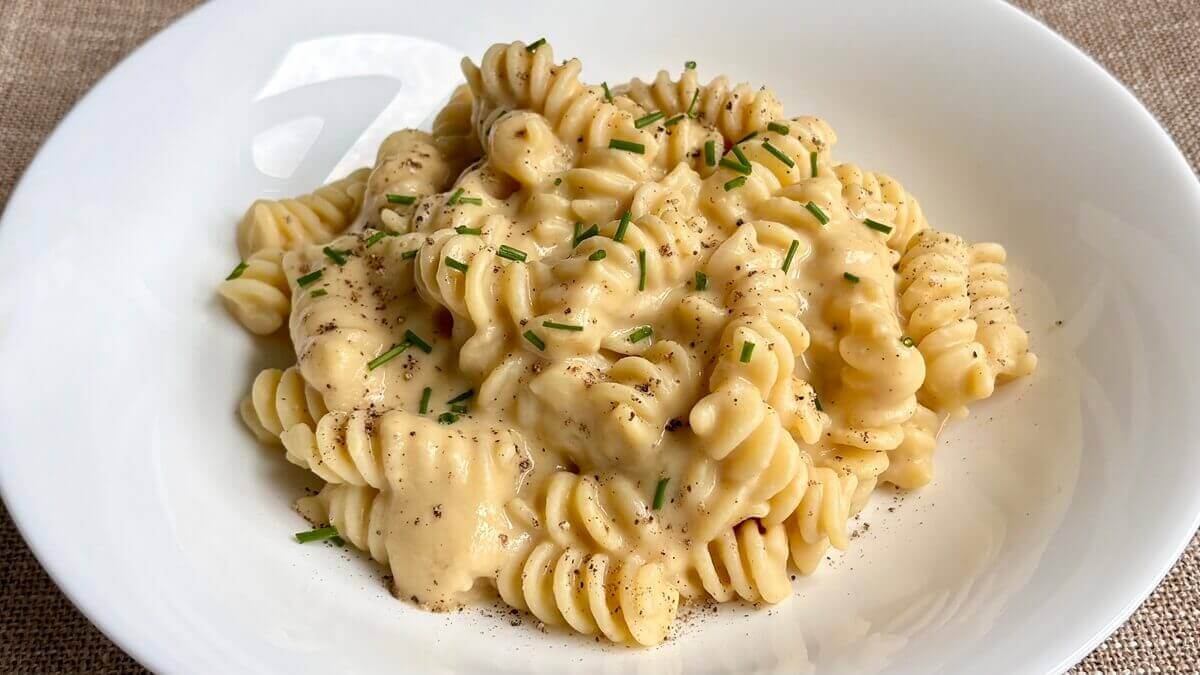 Pasta with a chickpea creamy sauce garnished with chopped chives.