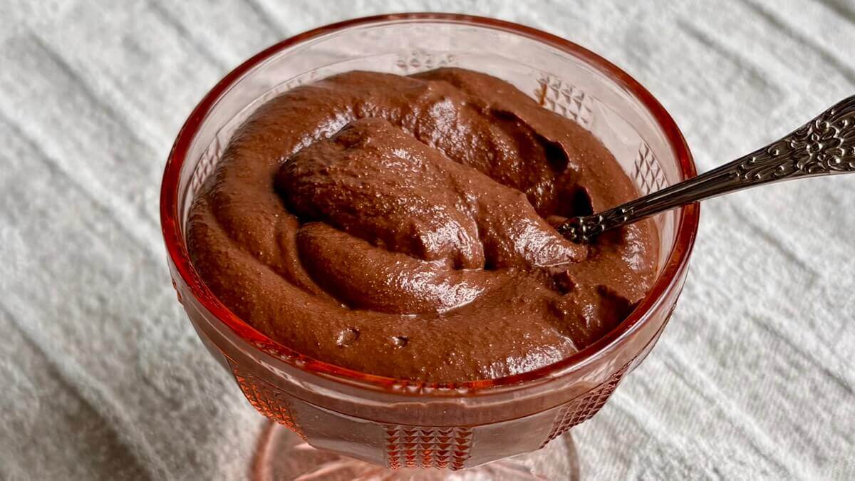 Chocolate walnut pudding in a pink glass dish.