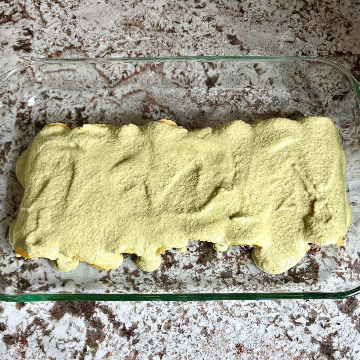 Creamy vegan enchiladas in a glass baking dish.