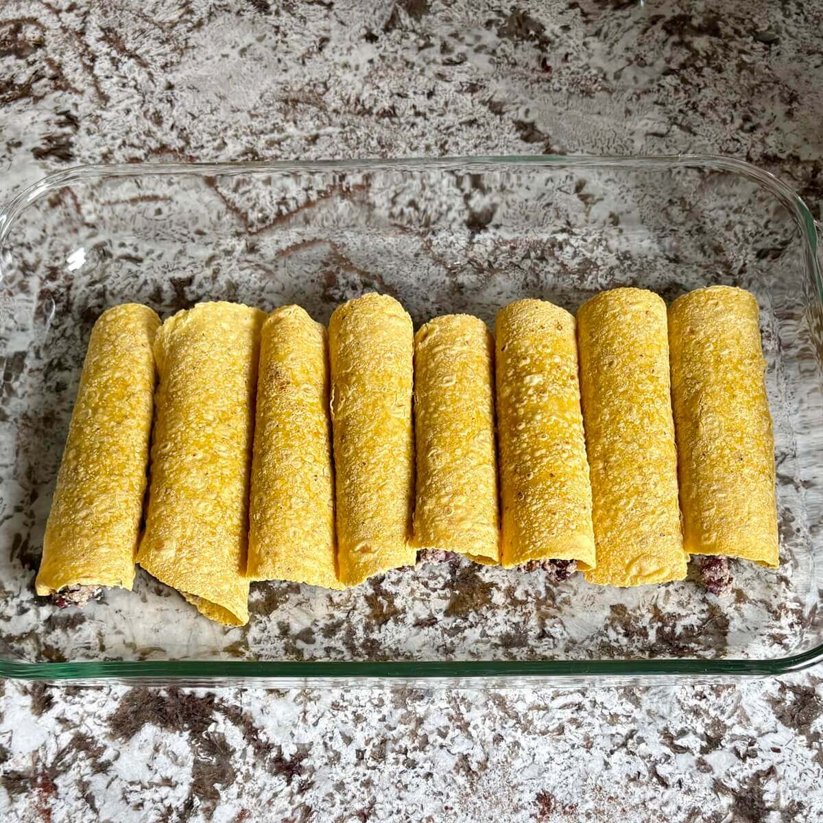 Enchiladas in a baking dish.