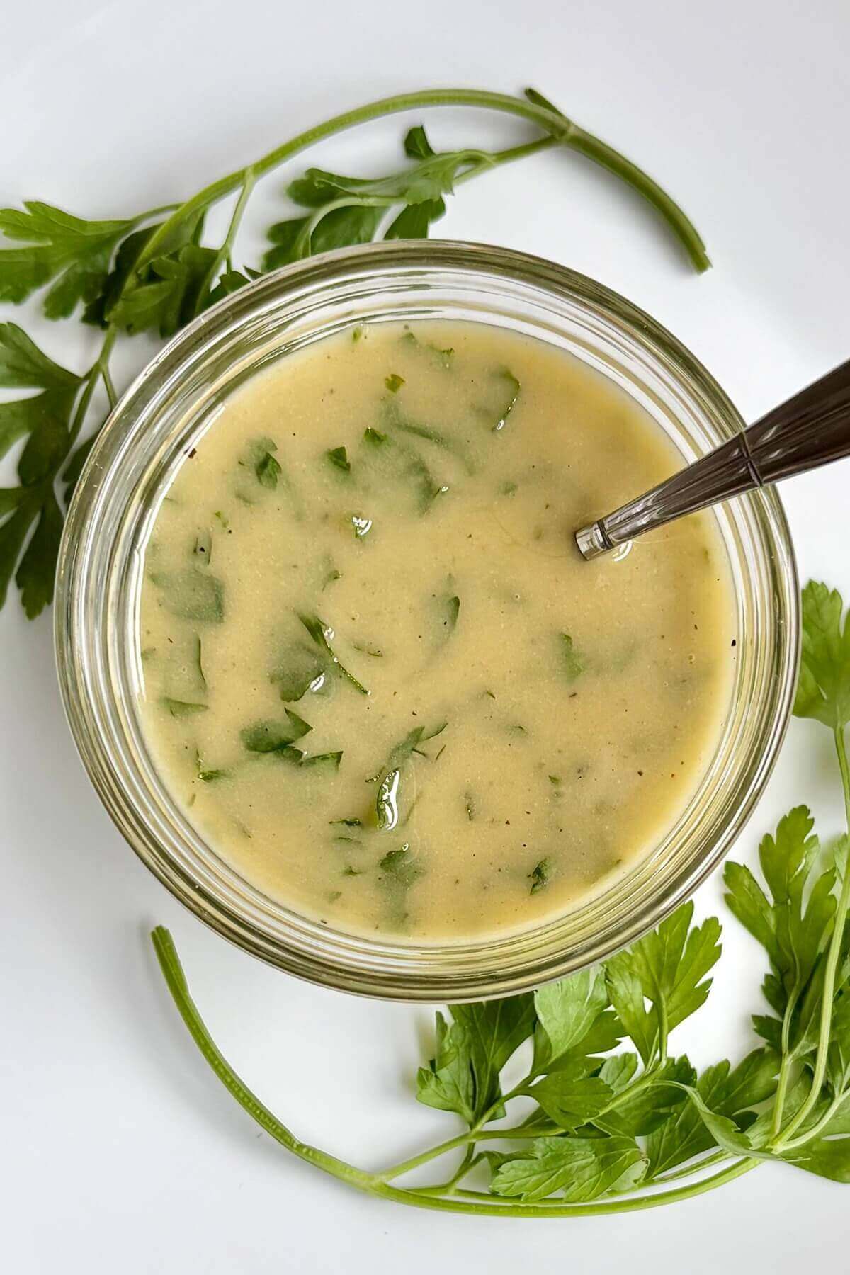 Salad dressing made with fresh parsley in a glass bowl.