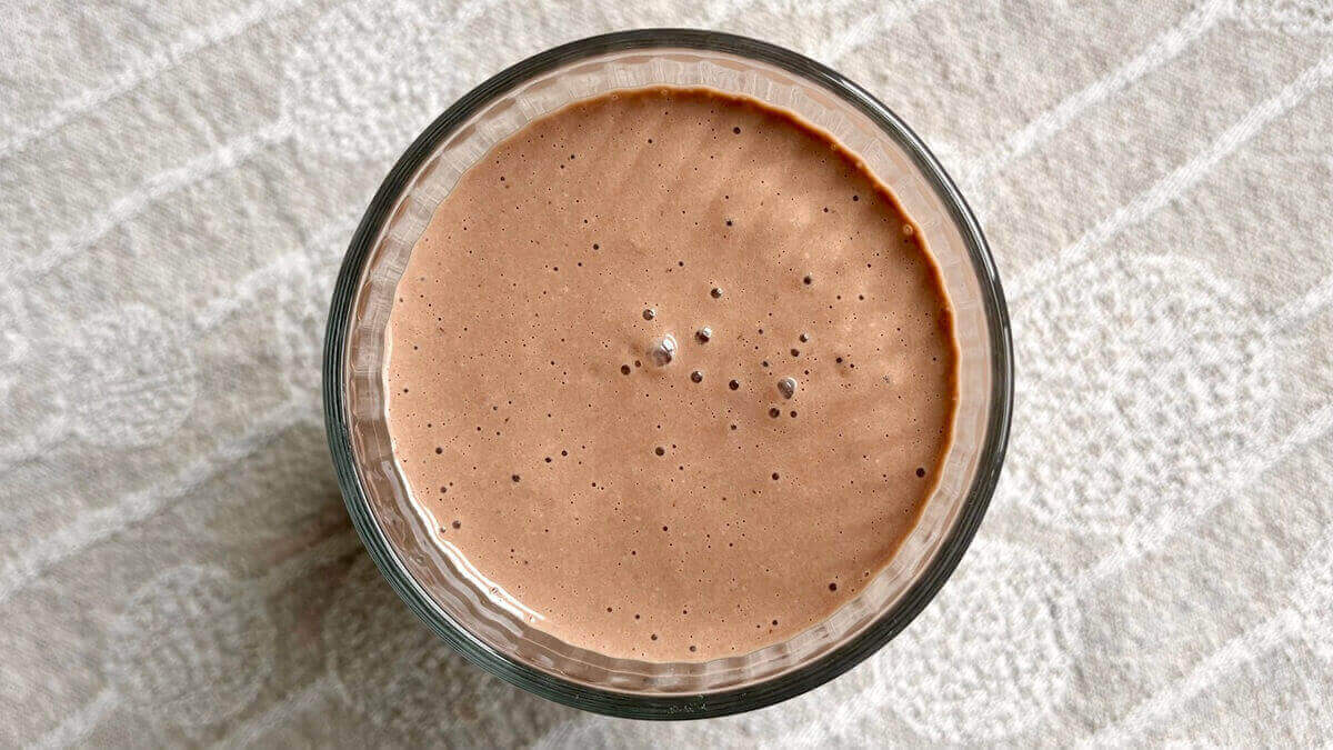 A creamy smoothie made with macadamia nuts in a glass.