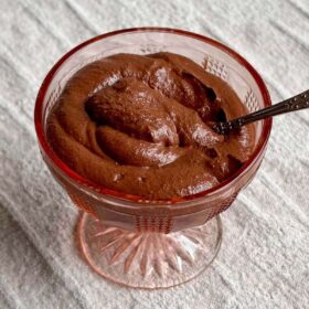 Walnut chocolate pudding in a vintage glass dish.