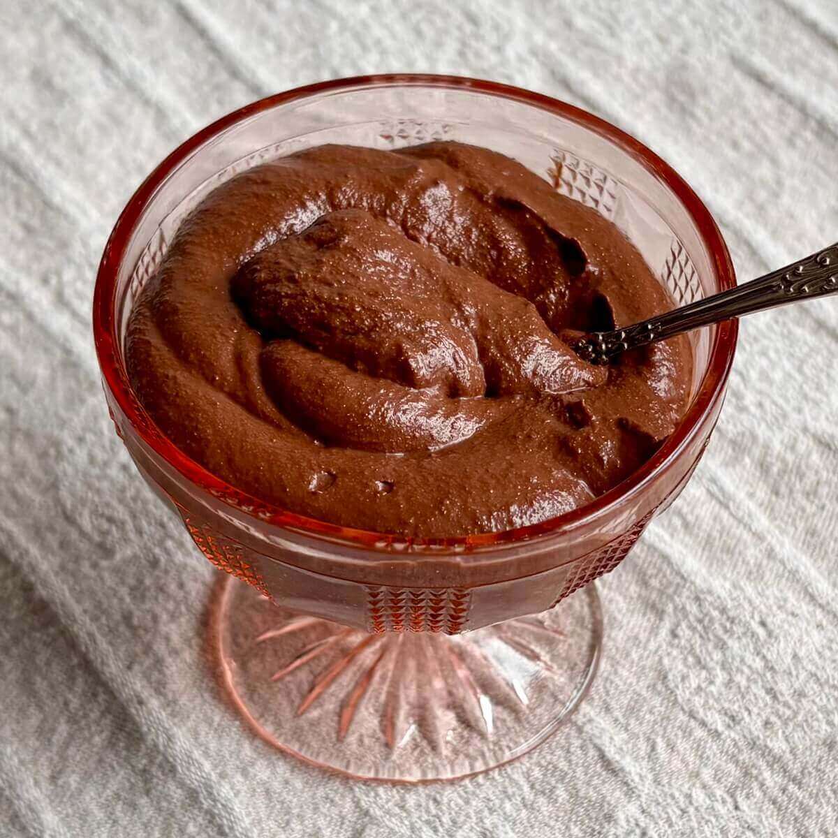 Walnut chocolate pudding in a vintage glass dish.
