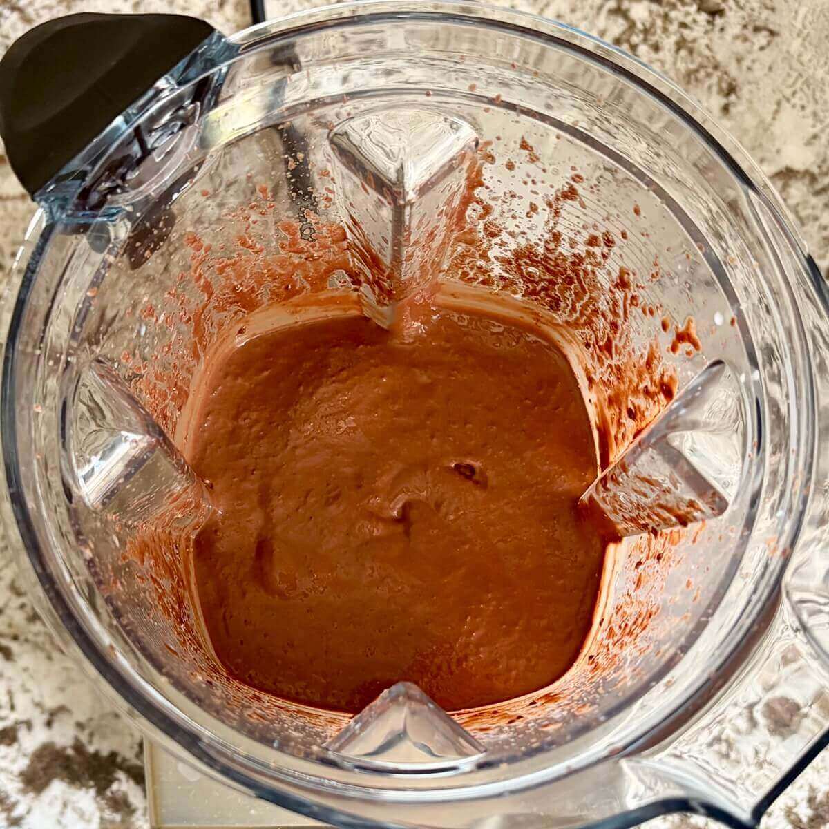 Chia seeds and other ingredients for chocolate mousse blended in a blender.