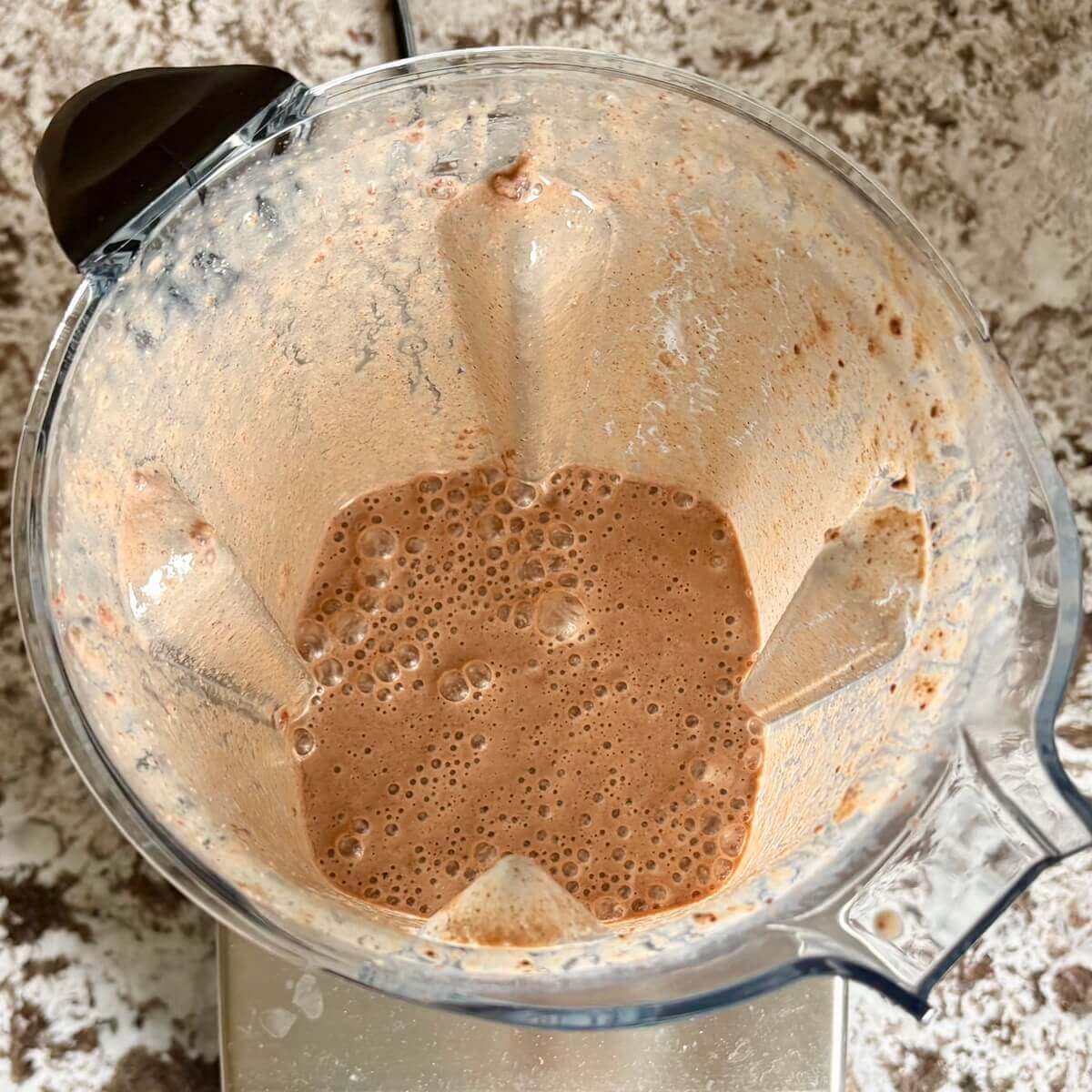 Chia seeds and other ingredients for a smoothie blended in a blender.